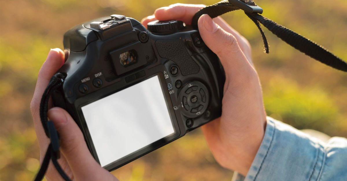 Persona sujetando una cámara en el campo